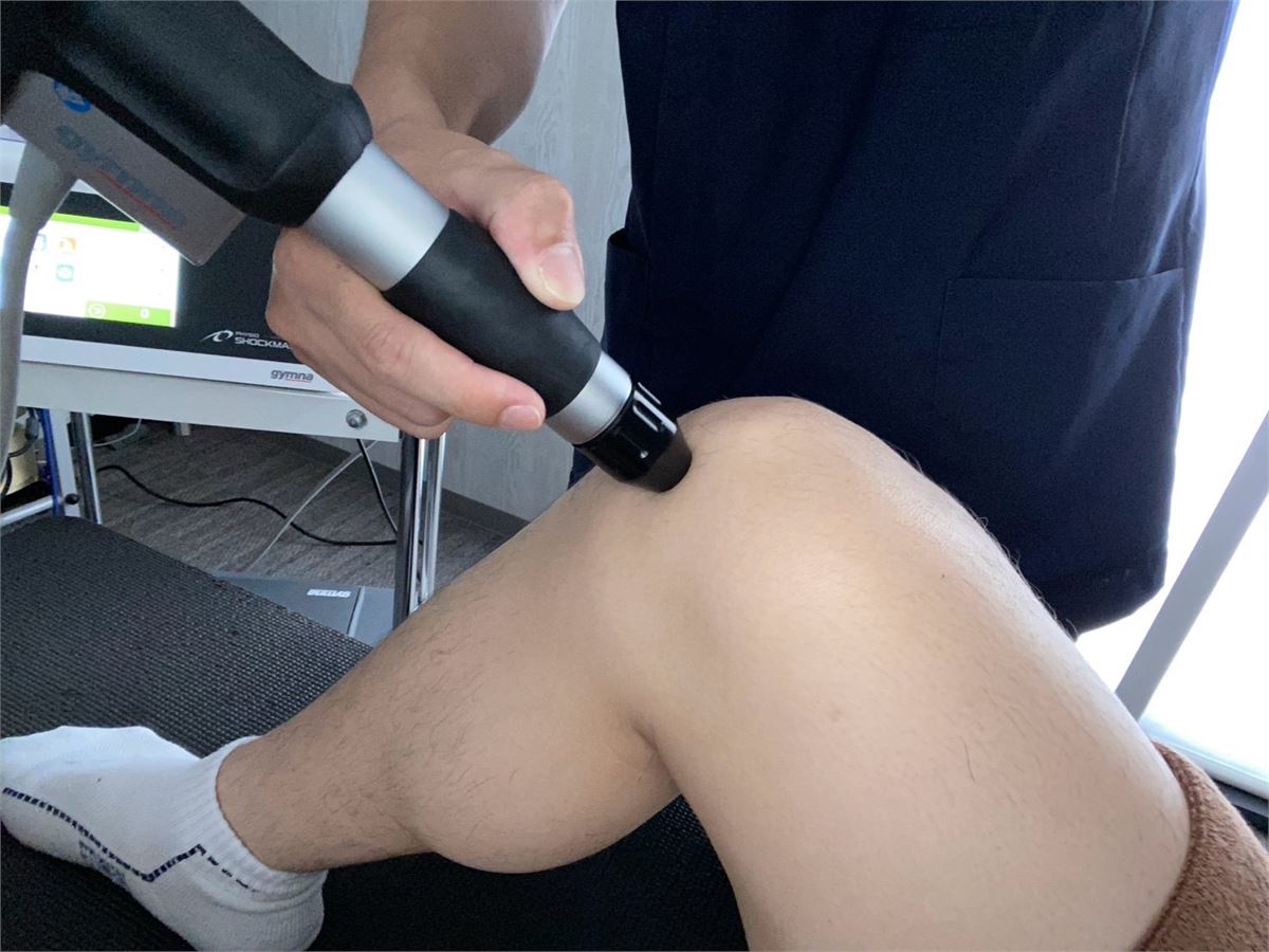 膝まわりへショックマスターの圧力波を照射している施術のようす